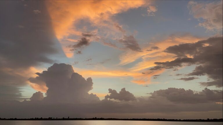 vecteezy_a-large-cloud-formation-over-the-water-at-sunset_75315449